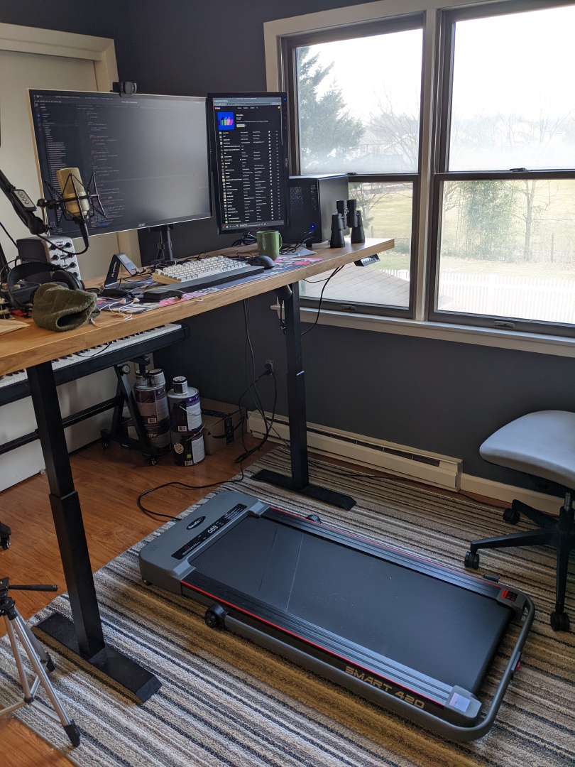 A standing desk with a treadmill under it